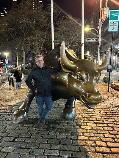 Photo of Adam next to a bull statue.