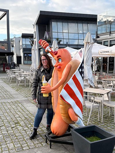 Photo of Merrill next to a hot dog statue.