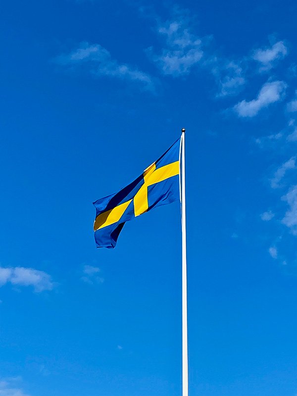 Swedish flag against blue sky.